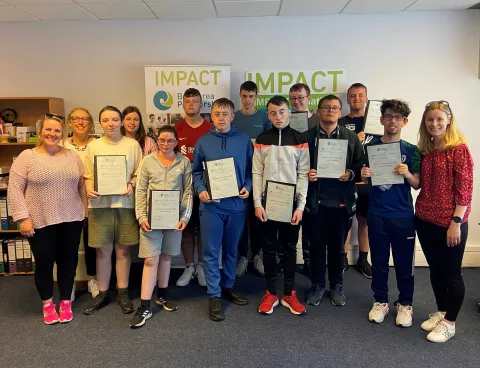 New Court Students standing holding their certificates, with teachers.