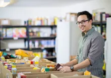 Man at bench making up food parcels